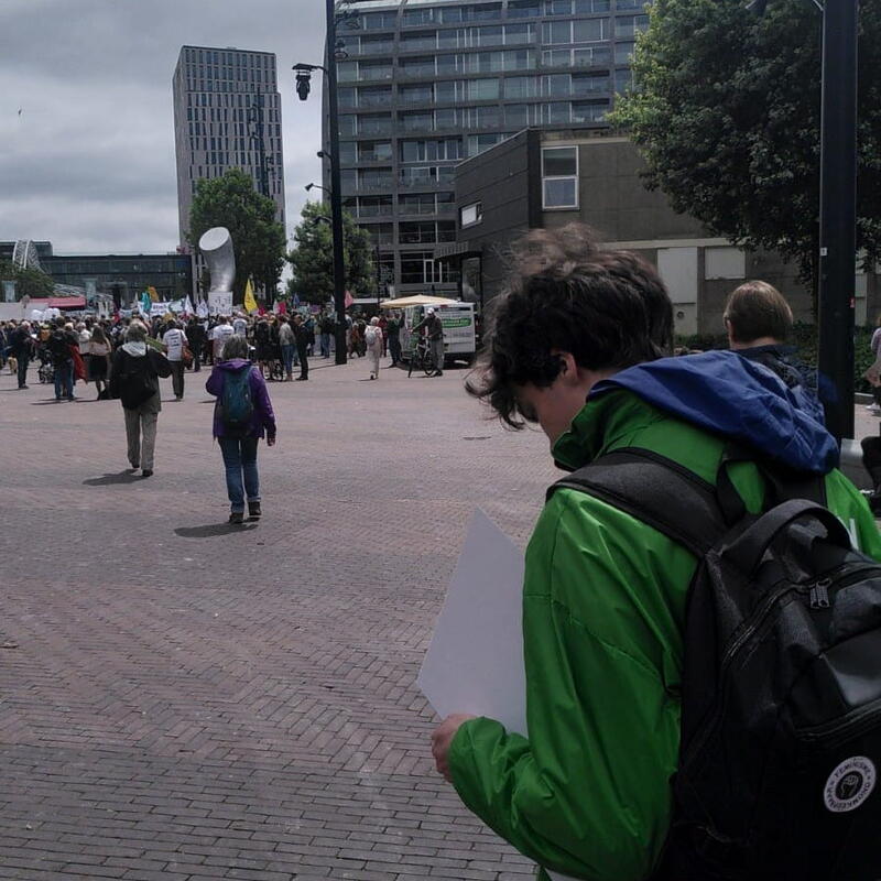 Iemand van GroenLinks Wijchen kijkt in Rotterdam waar de Klimaatmars start.