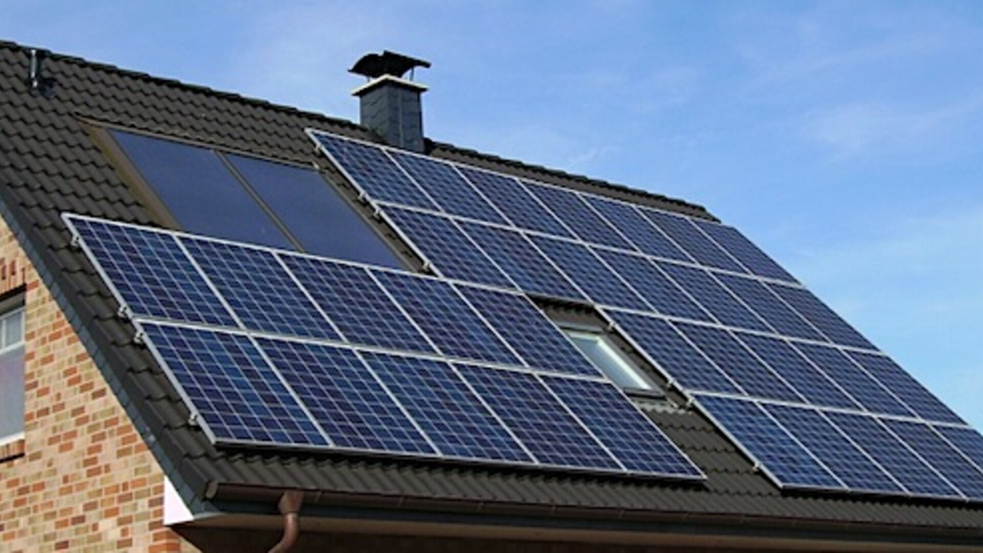 Een dak van een woonhuis met zonnepanelen.